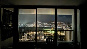 Una habitación con un ventanal grande que da a un paisaje urbano nocturno.