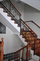 Una escalera con peldaños de madera y barandillas de metal negro.