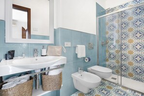 Een douche, een haardroger, een bidet, handdoeken