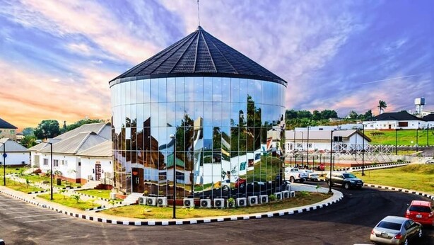 Un edificio amplio y moderno con una cúpula distintiva y fachada de vidrio reflectante.