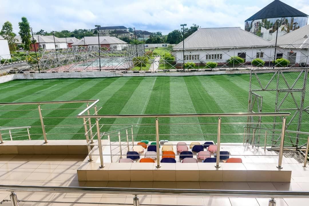A stadium with tiered seating and a green field.