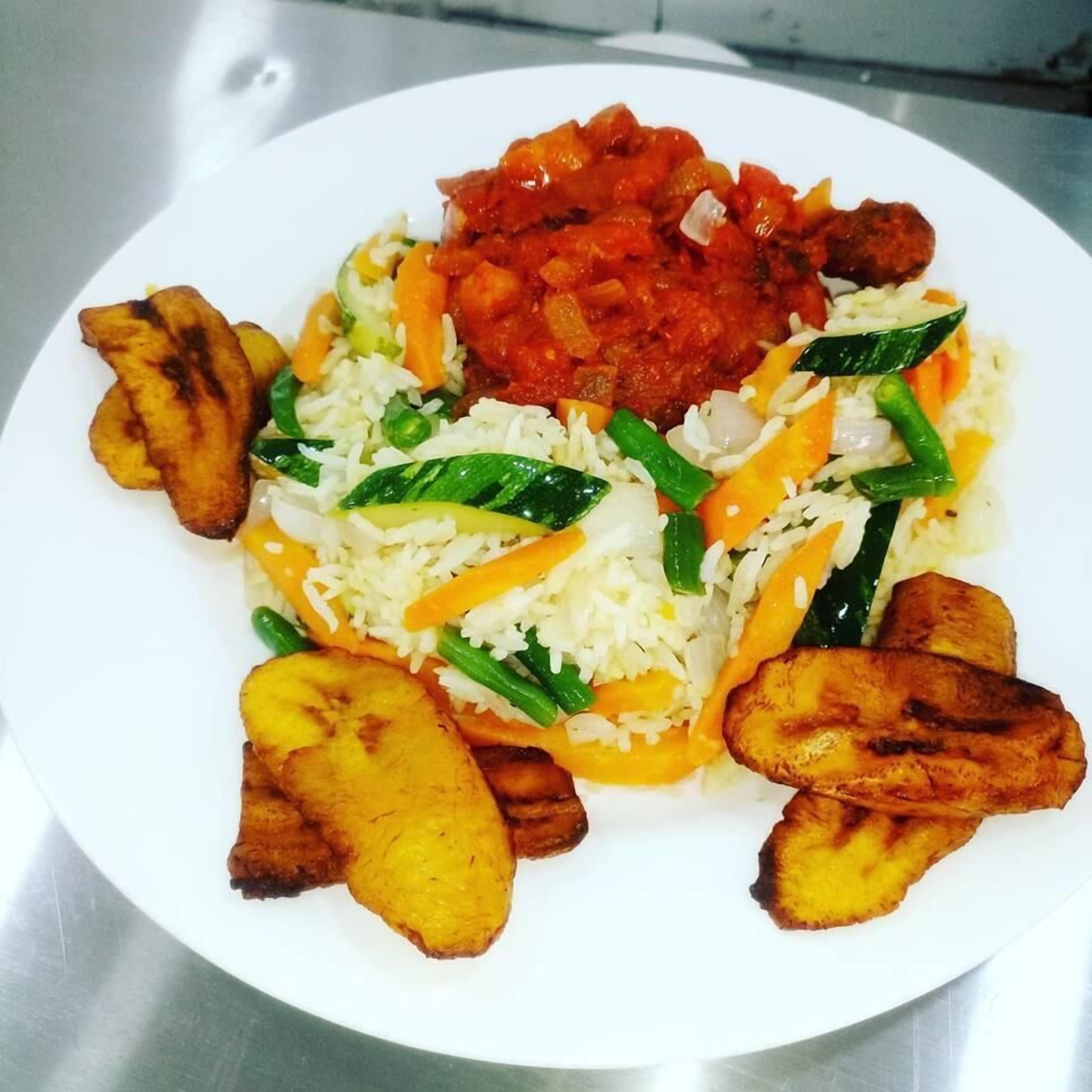 A plate of food with rice, vegetables, and fried plantains.