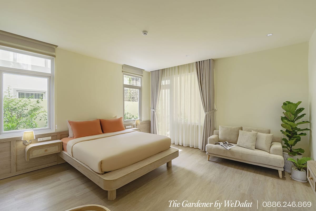 A bedroom with a bed, bedside table, lamp, and a window with curtains.