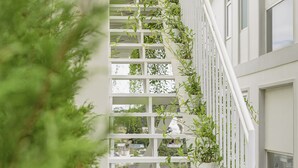 A white staircase with plants growing along the railing, leading to a balcony. - The Gardener by WeDalat (Xuan Huong - Da Lat)