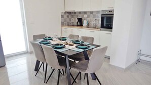 Una cocina moderna con armarios blancos, un salpicadero de azulejos y un horno empotrado.