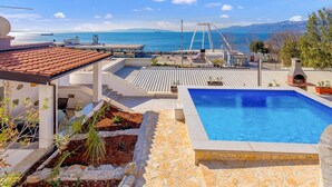 Ein Pool auf dem Dach mit Blick auf das Meer und die Berge.