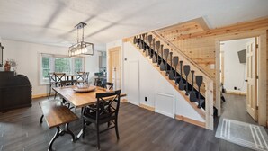 Una cocina moderna con una mesa y sillas de madera, un horno empotrado y un ventanal grande.