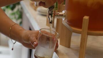 A person filling a glass with a beverage from a tap.