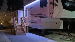 Een ruime camper met een overdekte veranda en een trap naar de ingang.