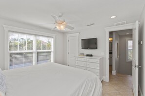 Relax in this serene bedroom with a large bed, ceiling fan, and flat-screen TV.