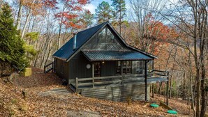 A cabin with a sloped roof, a porch, and a chimney. - Sunrise and Stardust - Hot Tub | Mountain Views | Screened Porch | (Morganton)