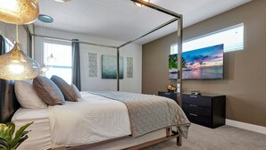 A bedroom with a four-poster bed, a flat-screen TV, and artwork on the wall. - Modern Oasis. Enjoy Resort amenities, 10 min to Disney and Attractions.  (Kissimmee)