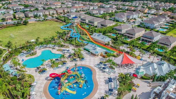 A water park with multiple slides and pools, surrounded by residential houses. - Modern Oasis. Enjoy Resort amenities, 10 min to Disney and Attractions.  (Kissimmee)