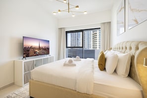 A modern hotel room with a large bed, a television, and a cityscape view. - 2BR | 2 Pools & Gym | Burj Khalifa | Dubai Mall (Dubai)