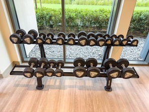 A set of adjustable dumbbells on a rack with a view of a garden through a window. - 2BR | 2 Pools & Gym | Burj Khalifa | Dubai Mall (Dubai)