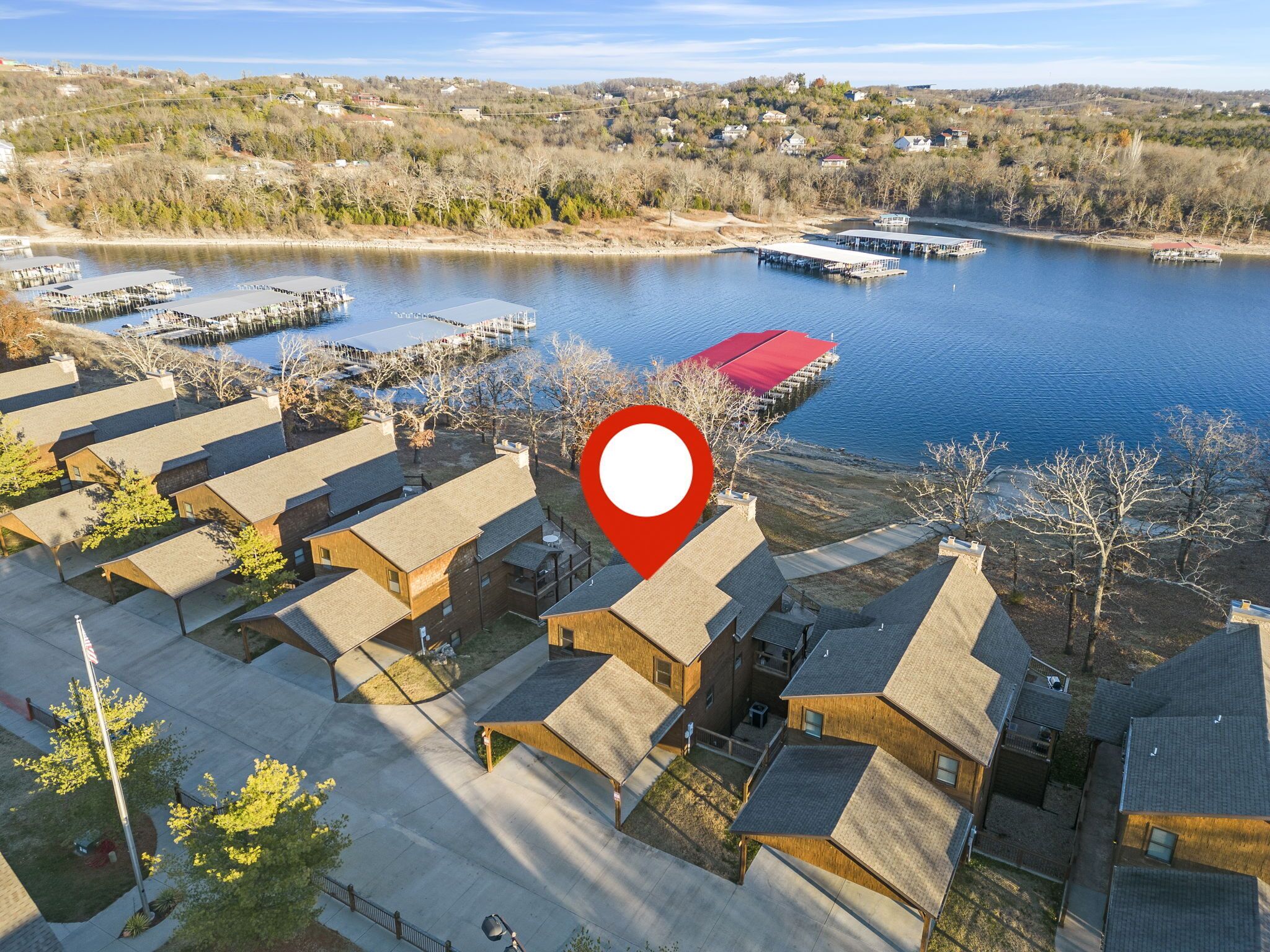 Vue aérienne d’un quartier résidentiel avec des maisons, un quai et un lac.