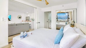 Une chambre d’hôtel avec un lit, un bureau, un canapé et une vue sur la ville.