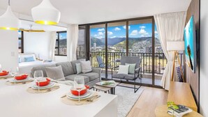 Une chambre d’hôtel moderne dotée d’un balcon, d’un coin repas et d’une grande fenêtre offrant une vue sur la ville.