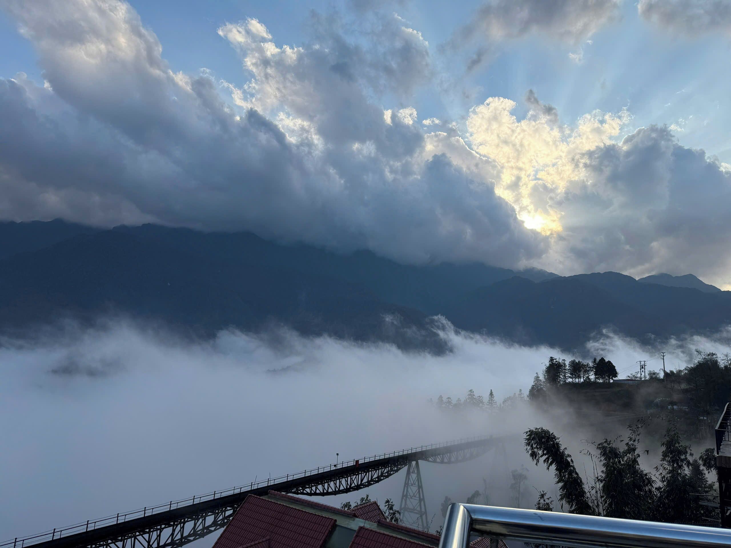 Un paysage de montagne avec un pont et des bâtiments au premier plan.