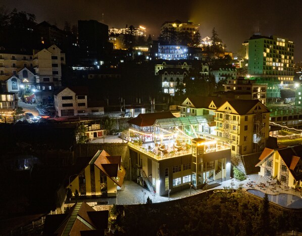 A hotel with a large glass facade, multiple balconies, and a swimming pool. - JOVILLE HOTEL SAPA (Sa Pa)