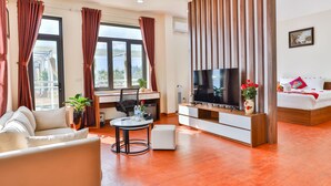 Una sala moderna con un sofá, televisor y una zona de comedor con mesa y sillas.