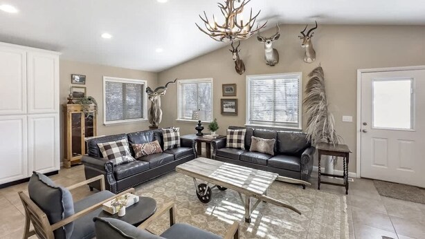 A living room with a sectional sofa, a coffee table, and a chandelier. - Mountain Meadow Retreat near Park City (Peoa)