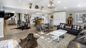 A spacious living area with a dining table, sofas, and a rug. - Mountain Meadow Retreat near Park City (Peoa)
