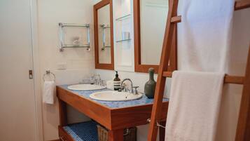 A bathroom with two sinks, a mirror, and a towel rack.