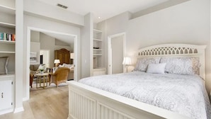 Ein Schlafzimmer mit einem großen Bett, einer Sitzecke mit Stuhl und Tisch sowie einem Kleiderschrank.