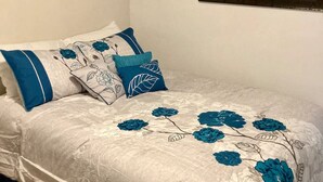 Een slaapkamer met een bed, een raam met een inspirerende quote en een raam met een landschap.