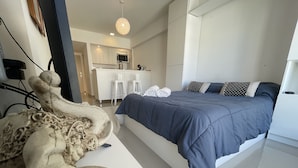 A modern bedroom with a large bed, a white desk, and a unique sculpture. - San Telmo Oasis Contemporary Luxurious Studios Num6863 (Buenos Aires)