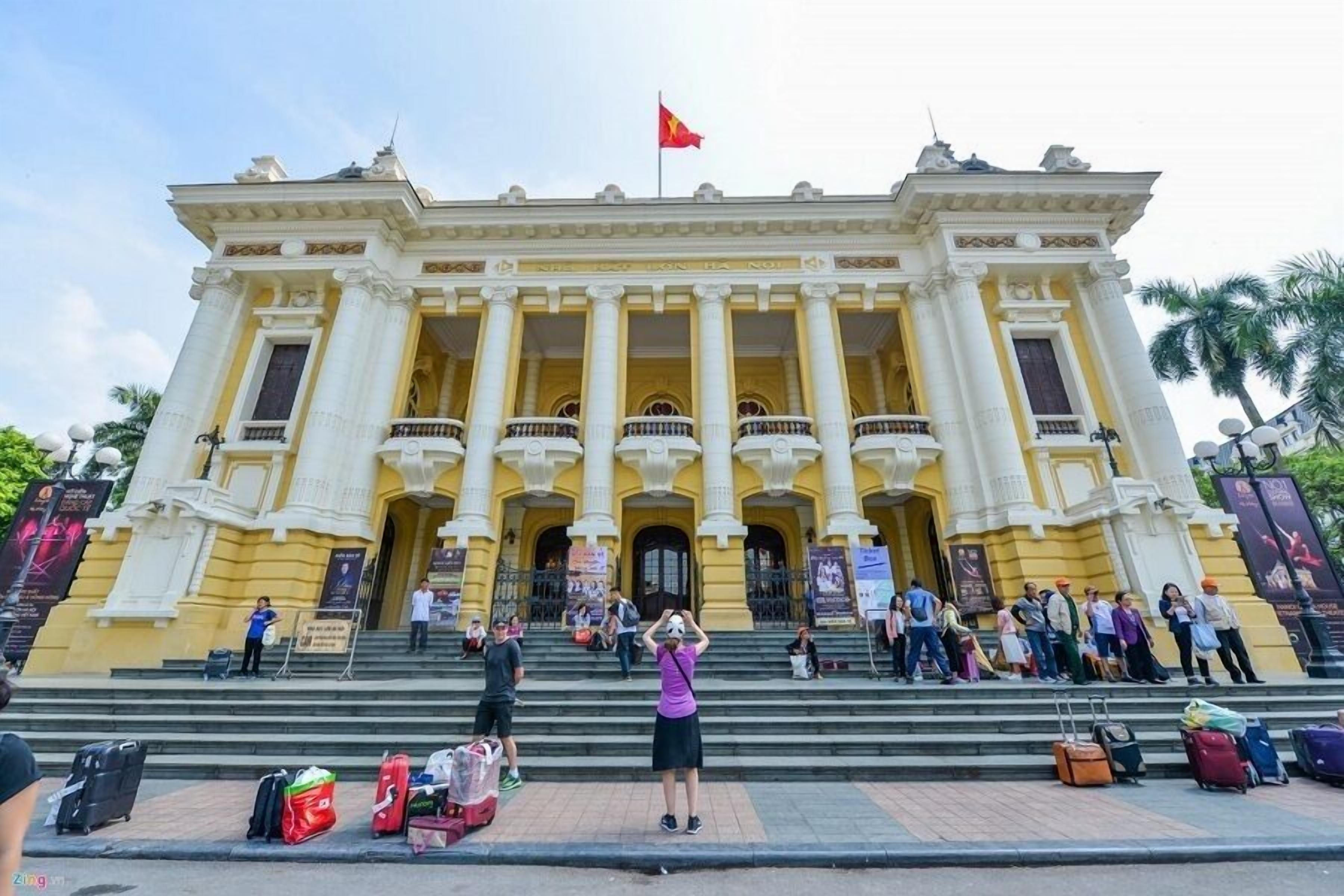 A grand building with a central entrance, multiple balconies, and a flag on top.