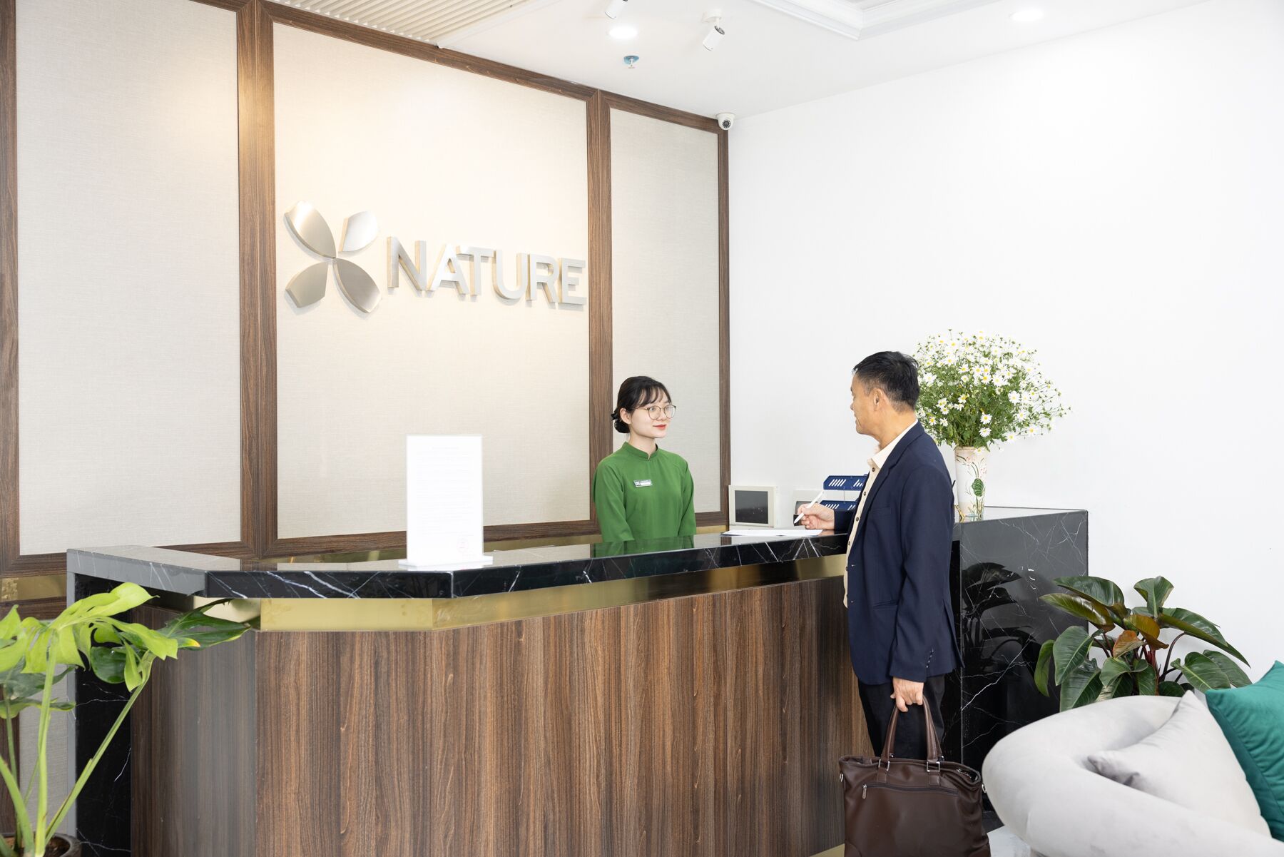 A reception desk with a wooden panel and a sign that reads "NATURE".