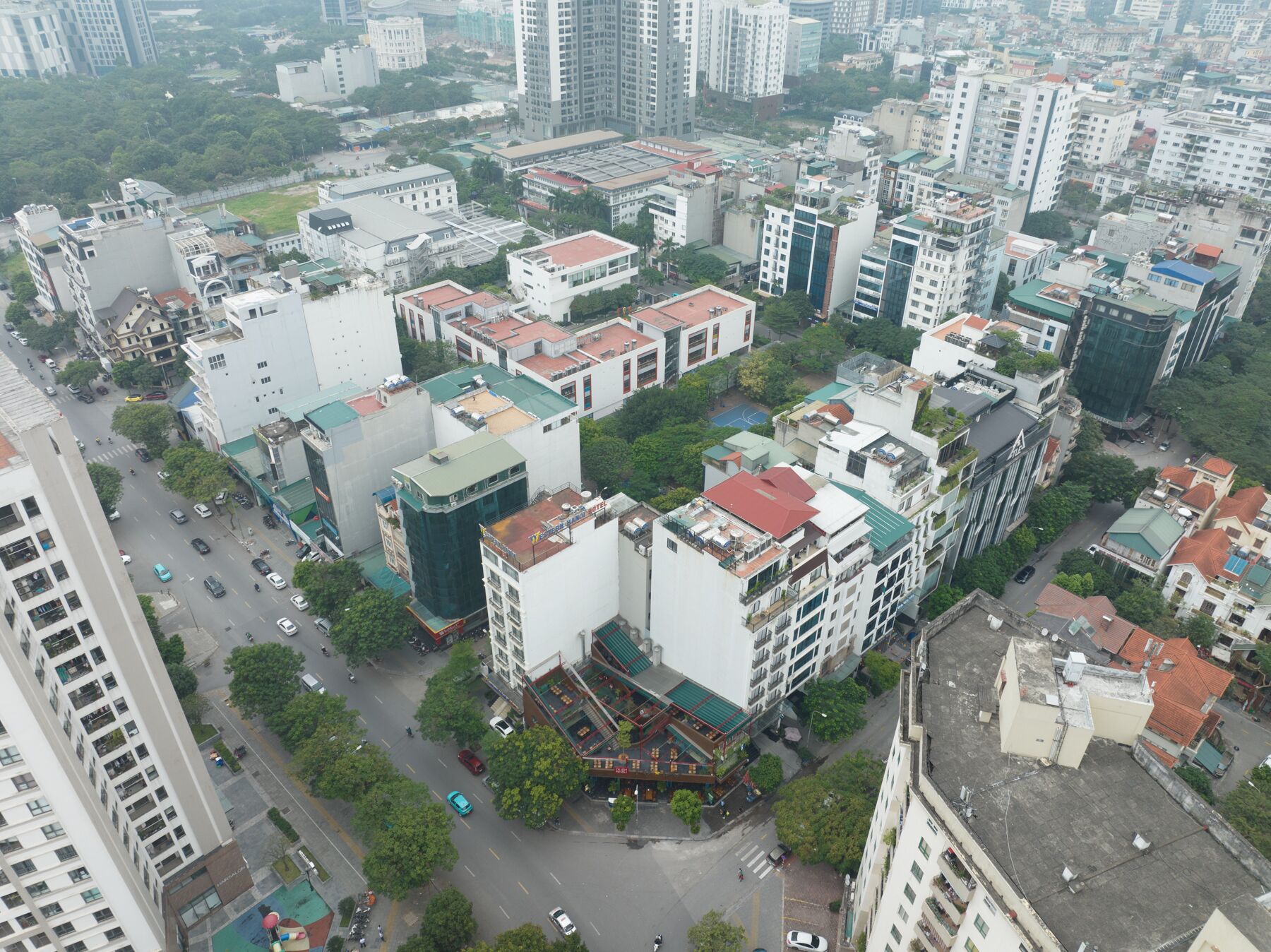 An urban area with high-rise buildings, a central plaza with a traditional-style building, and a busy street with vehicles.