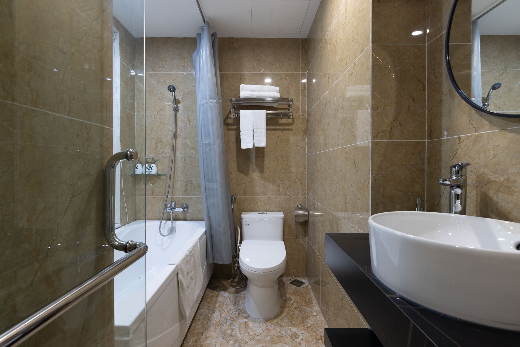 A modern bathroom with a bathtub, toilet, and sink.