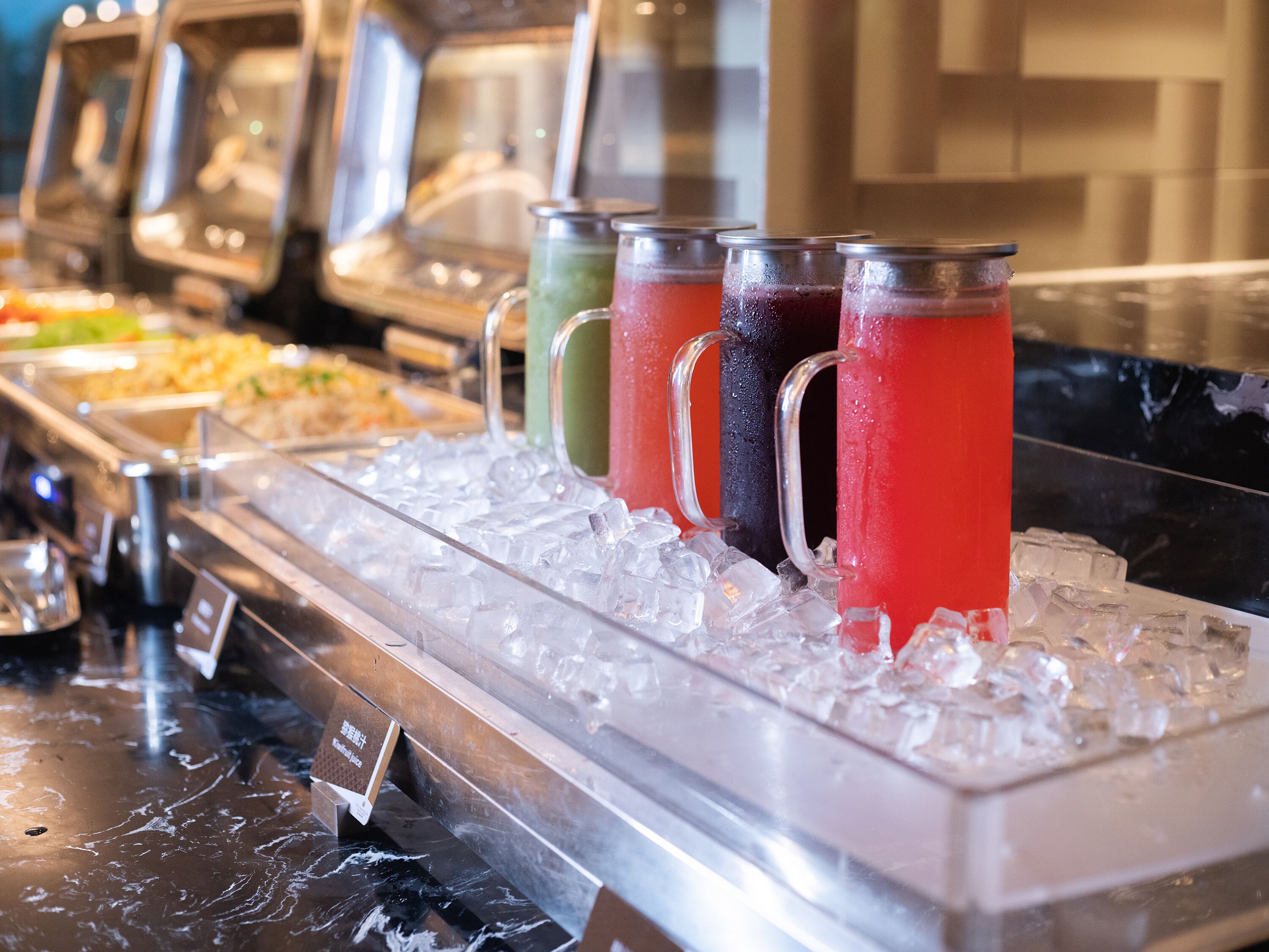 Un buffet proposant diverses boissons servies en carafes, ainsi qu’un assortiment de plats.