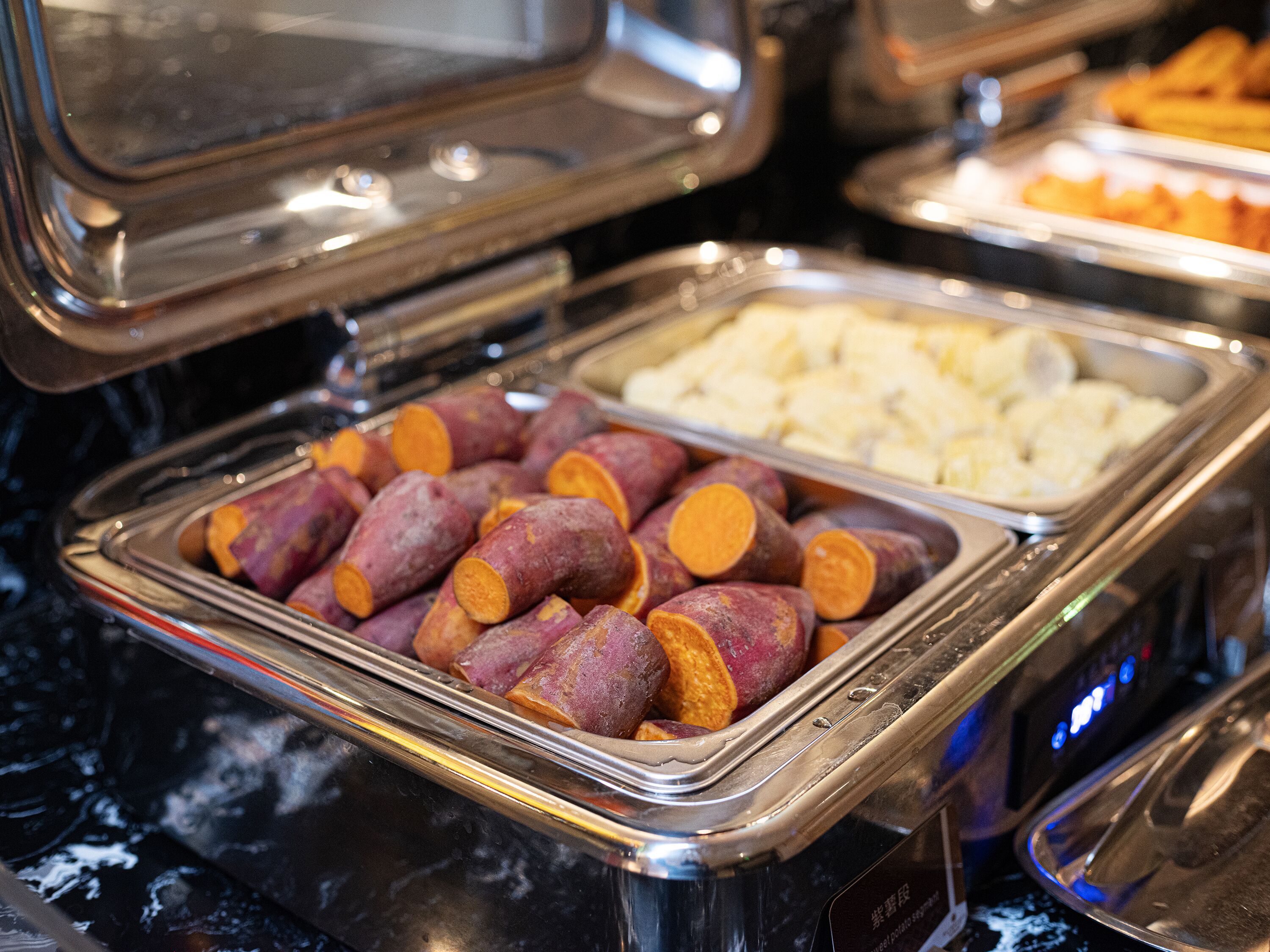A buffet with various food items, including sweet potatoes and other dishes.