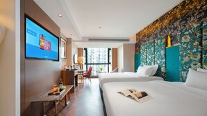 A hotel room with a large bed, a desk with a chair, a TV mounted on the wall, and a window with a view of buildings. - Zhangjiajie Metropolo Hotel (Zhangjiajie)