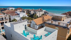 Zona residencial costera con edificios de techos rojos y paredes blancas, con vista al mar.