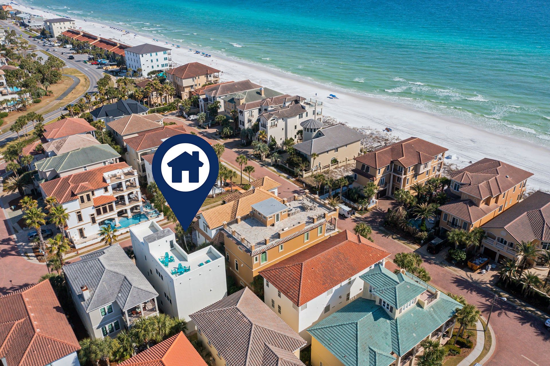 Zona residencial costera con una combinación de edificios de uno y varios pisos, algunos con balcones visibles y una playa al fondo.