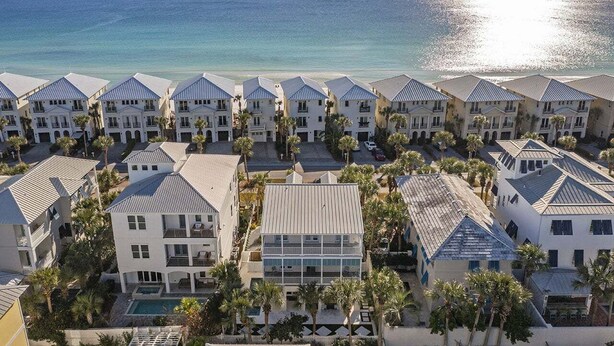 A resort with multiple buildings, a pool, and a view of the ocean.
