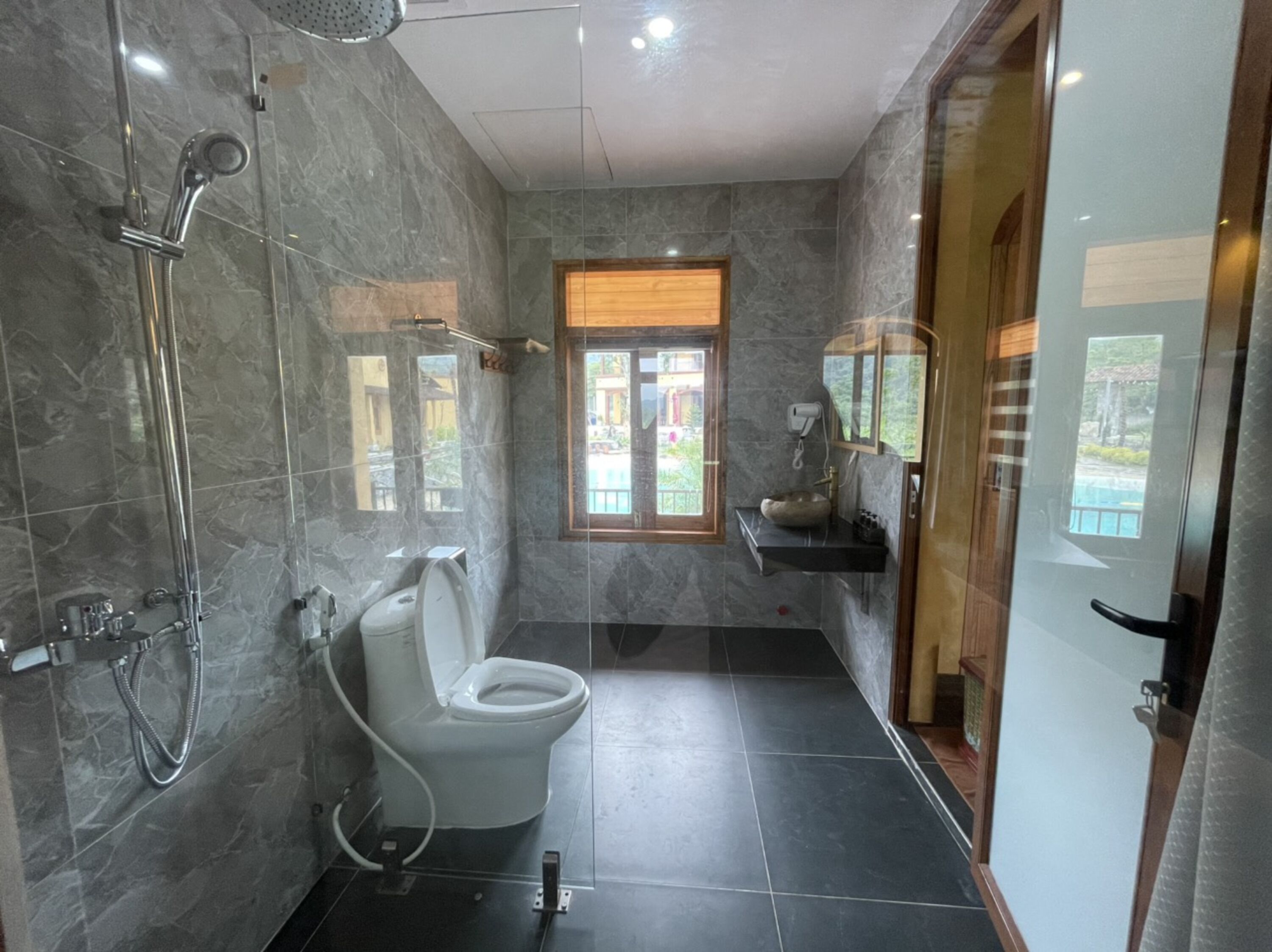 A modern bathroom with a toilet, shower, and sink.