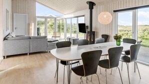 Un interior moderno con comedor, sofá y chimenea.