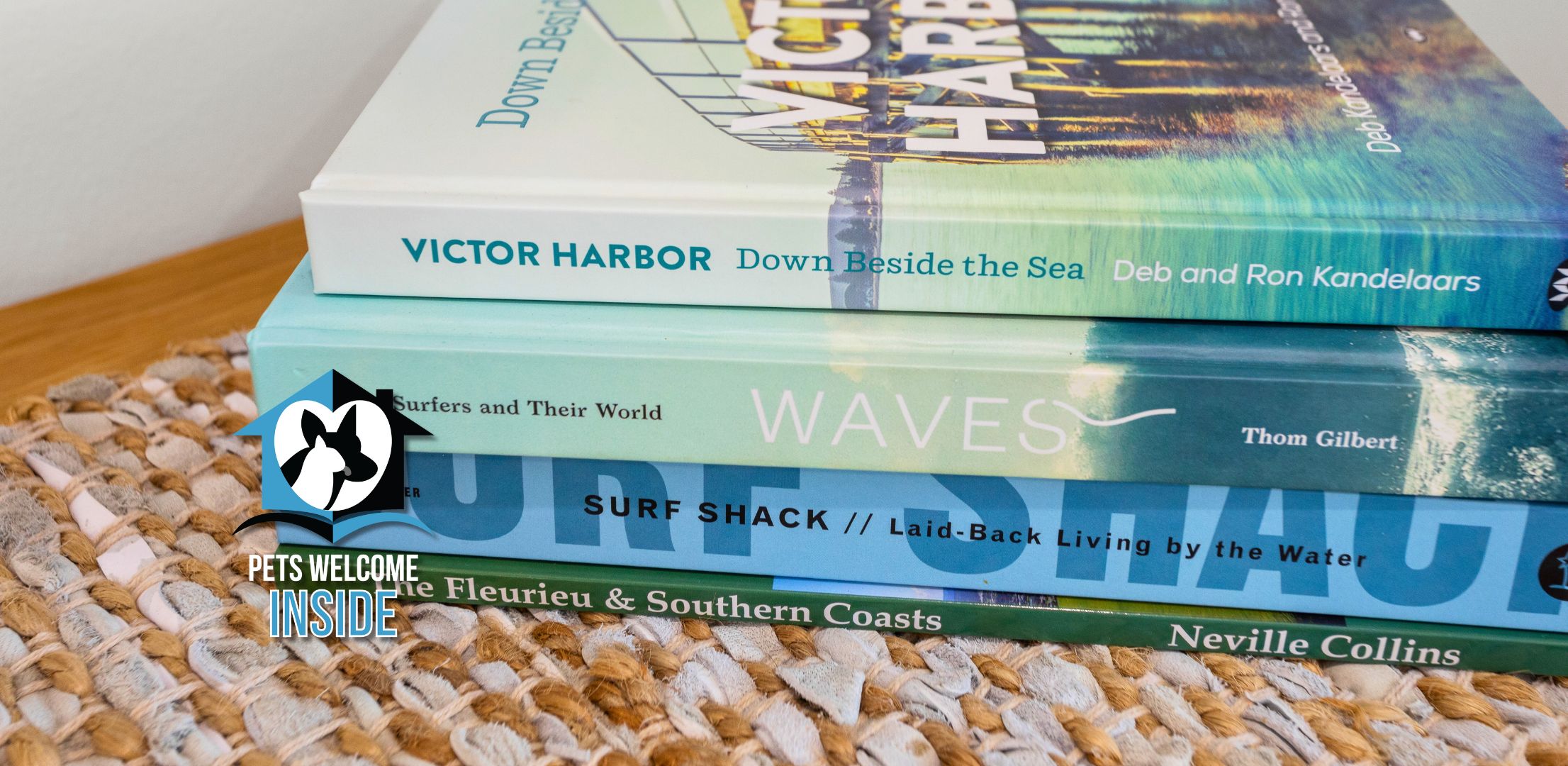 A stack of books with titles related to coastal and surf themes.