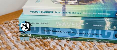 A stack of books with titles related to coastal and surf themes.