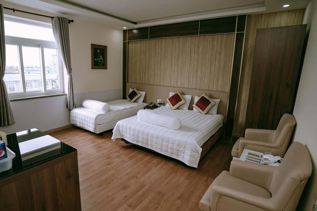 Een hotelkamer met twee bedden, een bureau en een stoel.