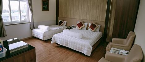 A hotel room with two beds, a desk, and a chair.