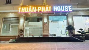 Un hôtel avec une enseigne bien visible indiquant « KHÁCH SẠN THUẬN PHÁT » et « THUẬN PHÁT HOUSE ».
