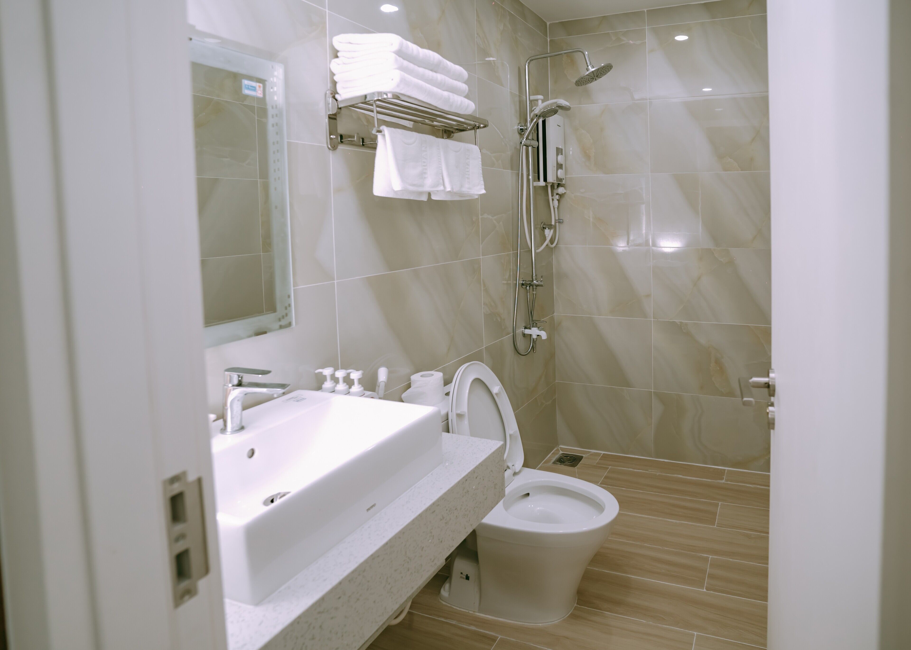 A modern bathroom with a sink, toilet, and shower.