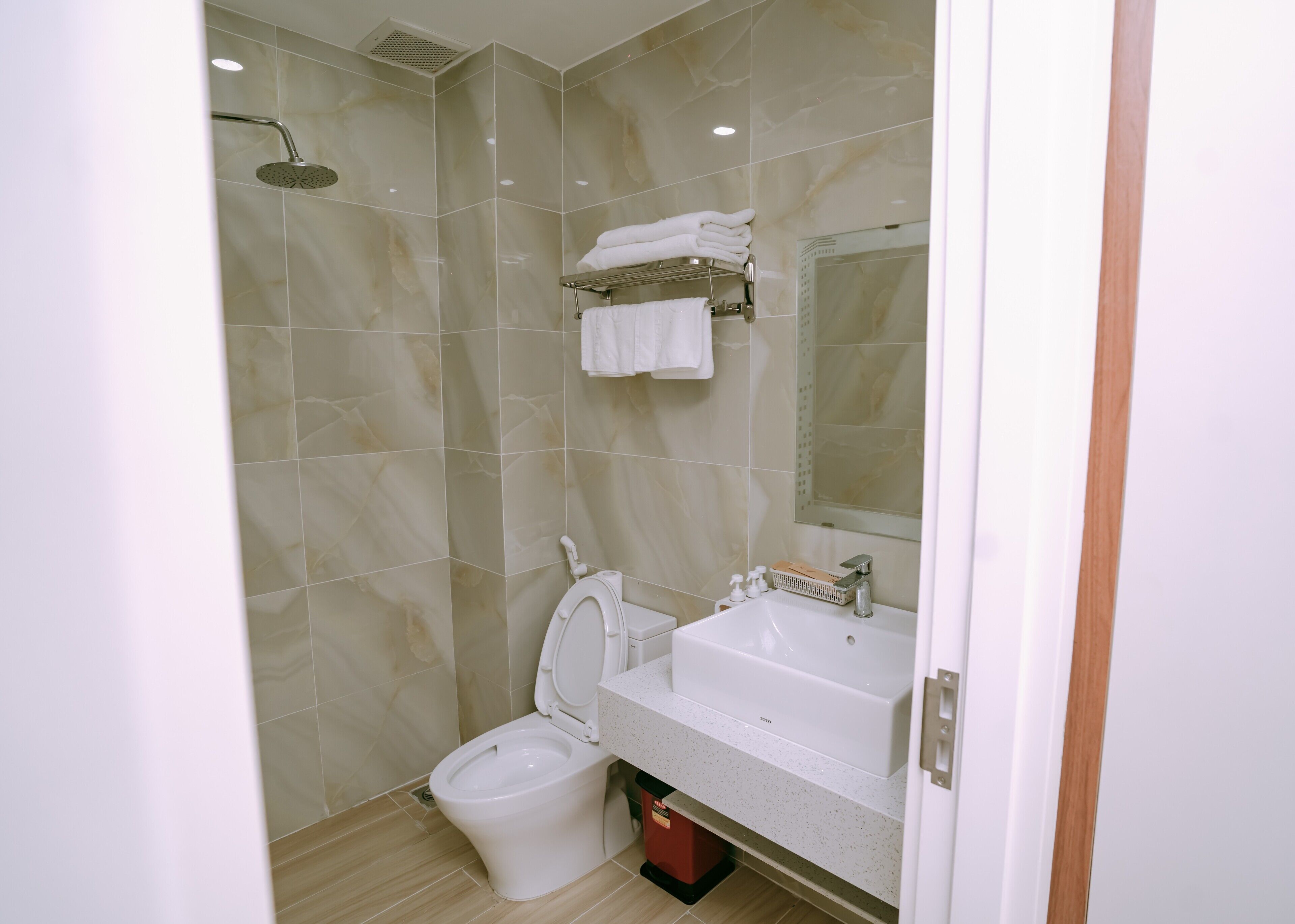 Een moderne badkamer met toilet, wastafel en douche.